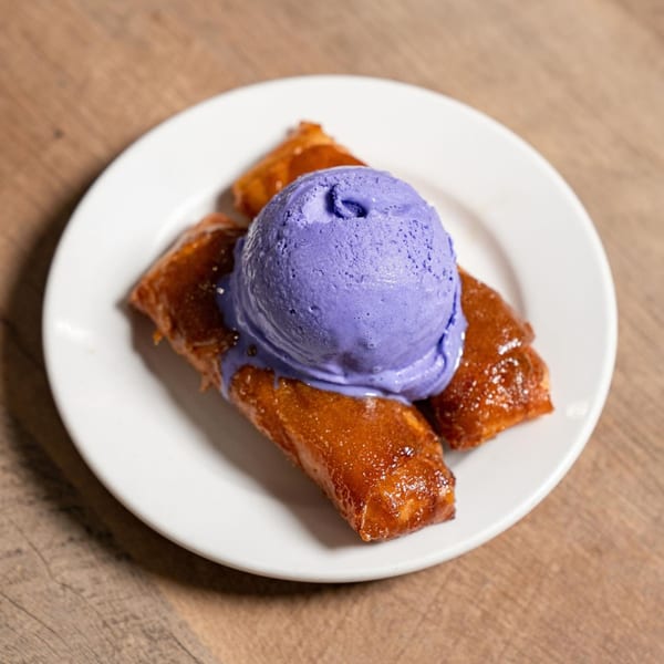 Matthew's Grill's turon with a scoop of vibrant purple ube ice cream on a white plate.